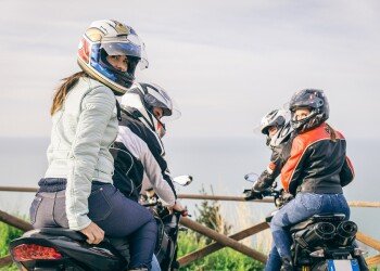 Zwei Pärchen auf Motorrad von hinten fotografiert